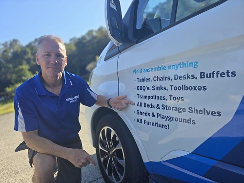 Technician - Robert, pointing a his services on the side of his van.