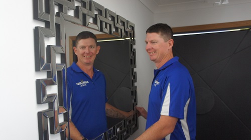Technician - Brendan, in front of a large mirror he installed.