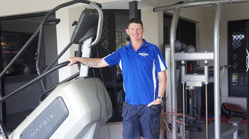Technician with Gym equipment he assembled.