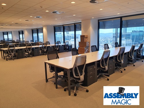 Conference room furniture installed by Assembly Magic. Assembly Magic logo in bottom right corner
