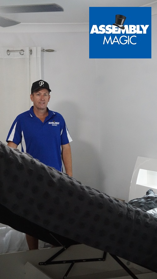 Technician with a bed he assembled. Assembly Magic logo in top right corner