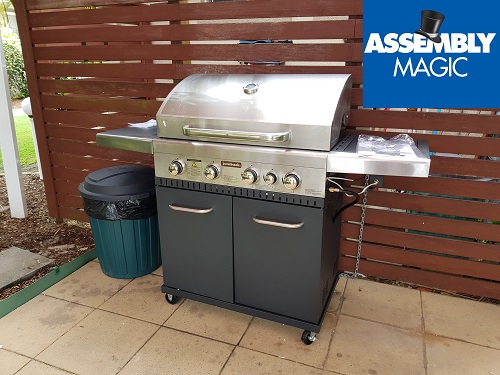 Stainless steel 4 burner BBQ with Assembly Magic logo in top right corner