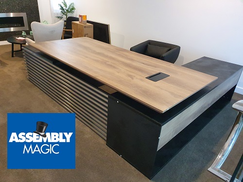 A large Office Desk setup with Assembly Magic logo in bottom left corner