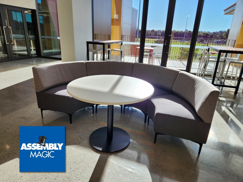 Round seating area with table and Assembly Magic Logo
